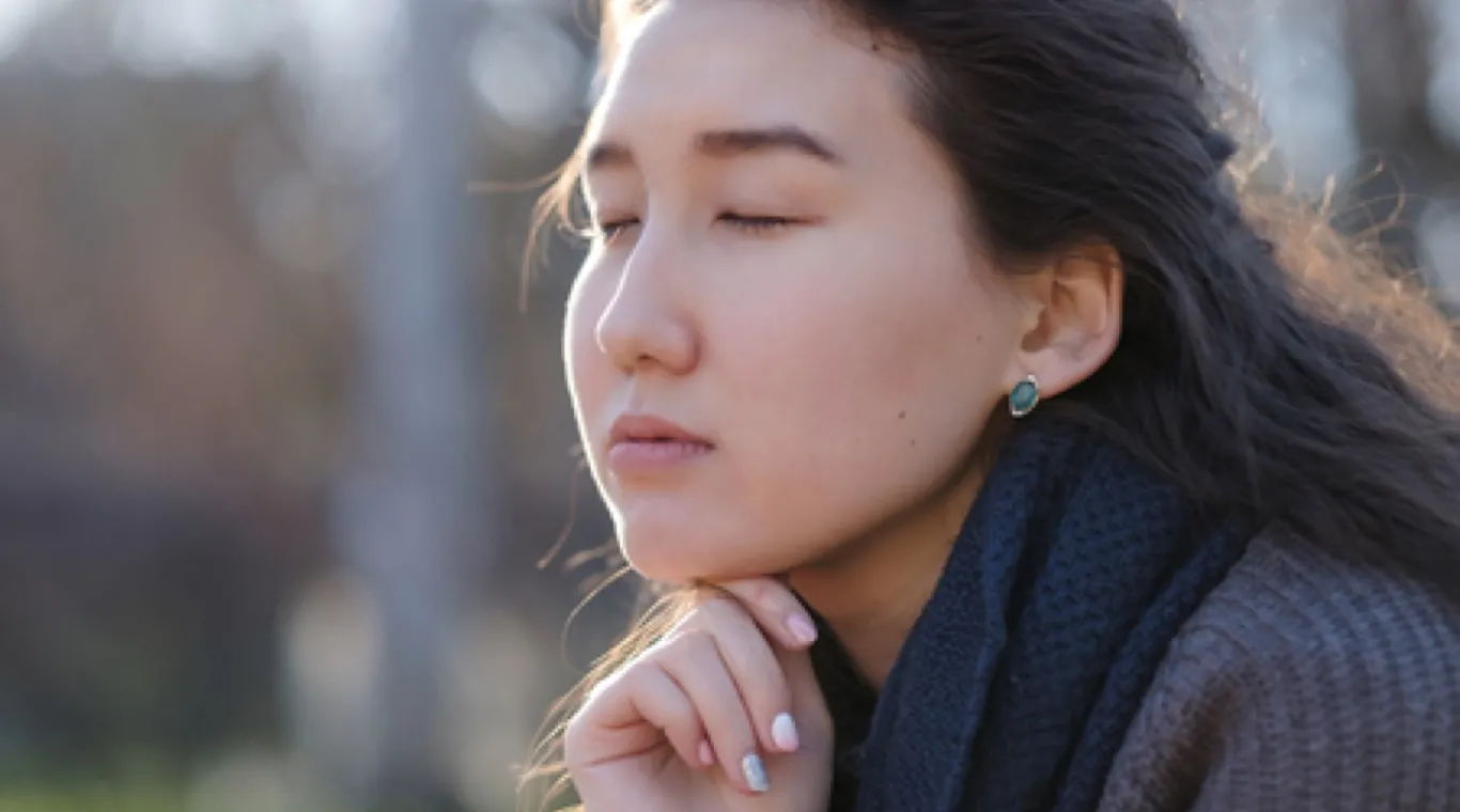 Woman thinking with hand on her chin.