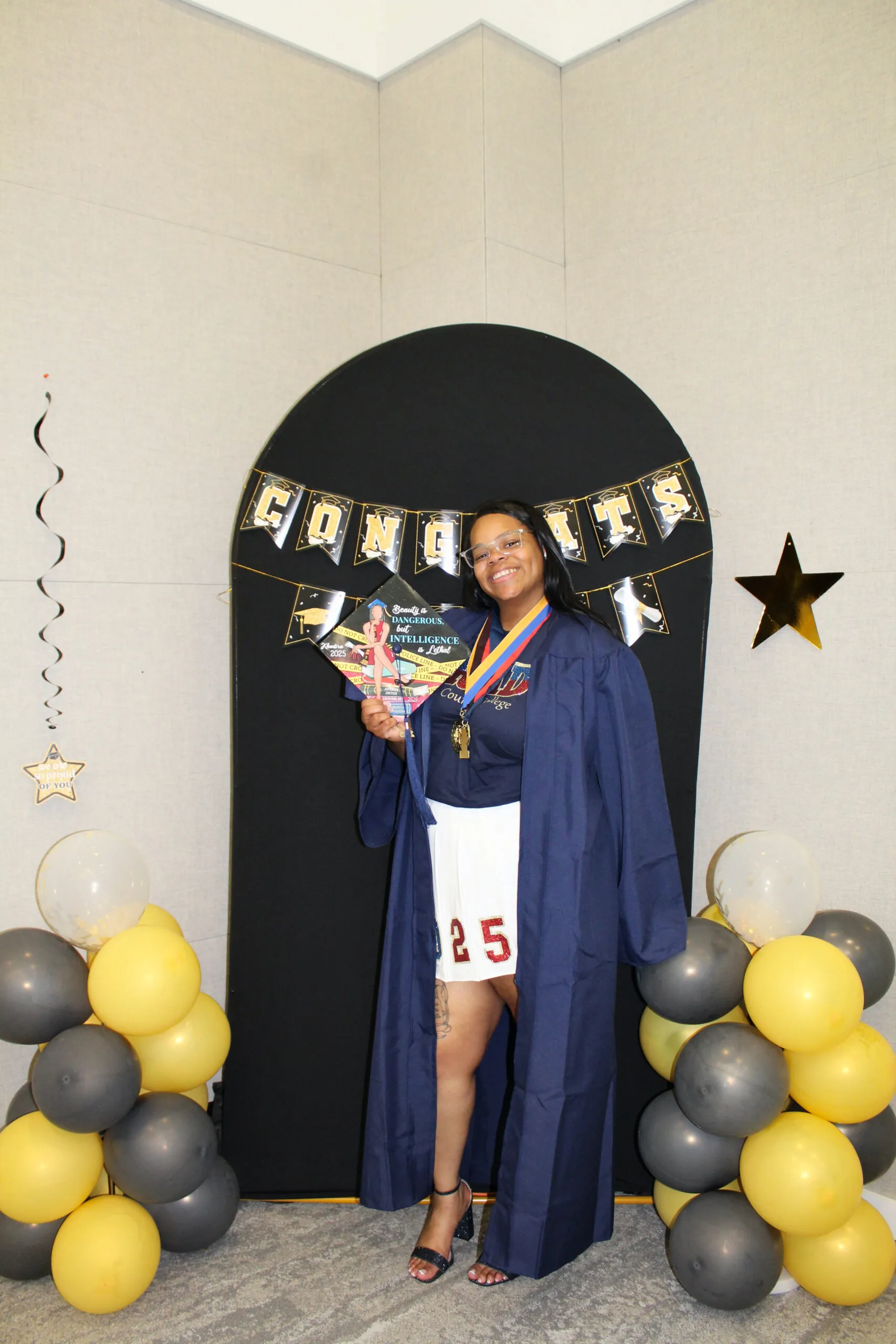 student posing with decorated graduation cap