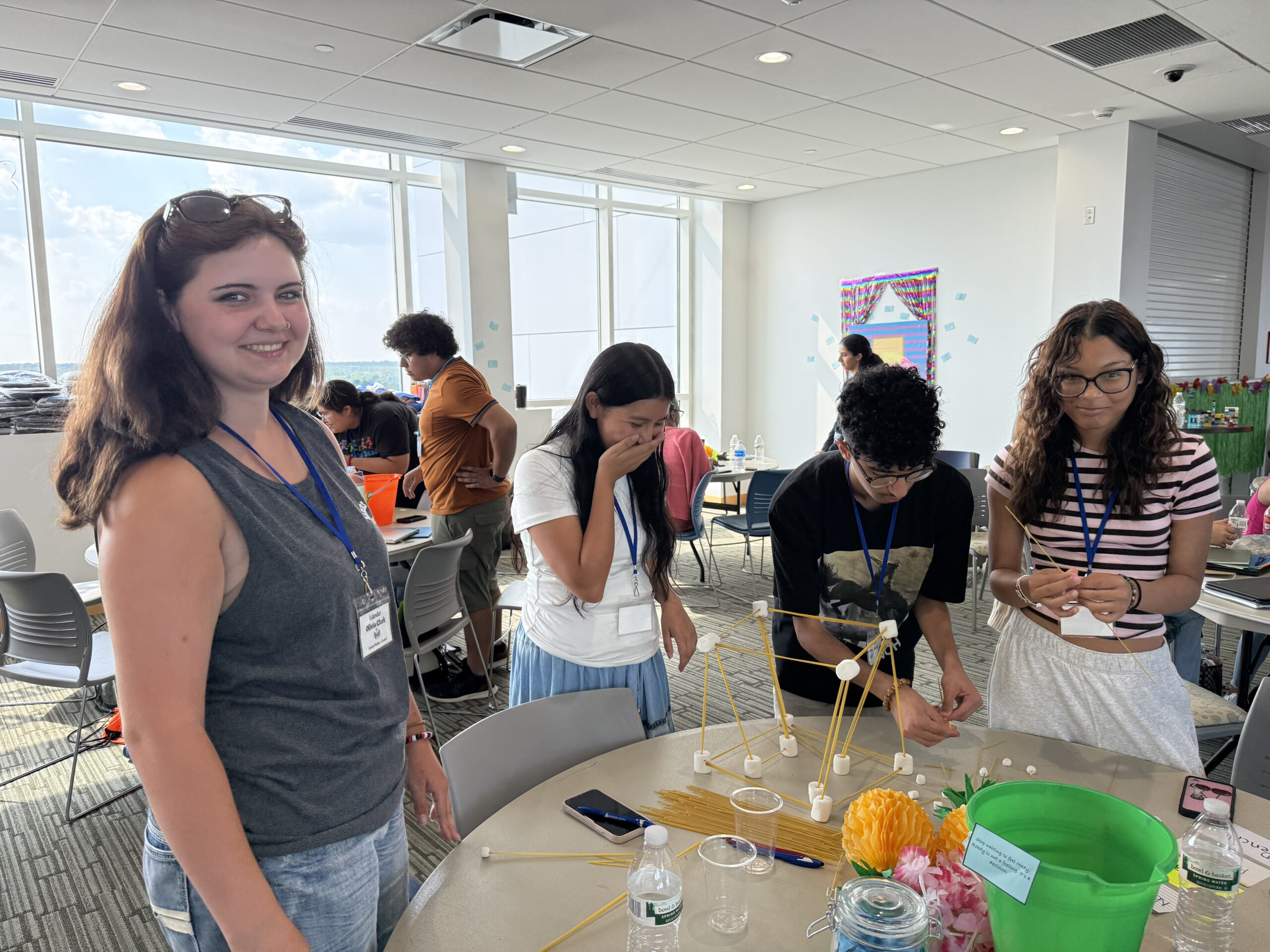 group of students at a table building a tower with spaghetti and marshmallows 