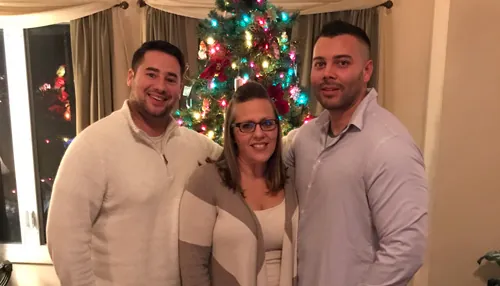 John Richards with two others in front of a Christmas tree