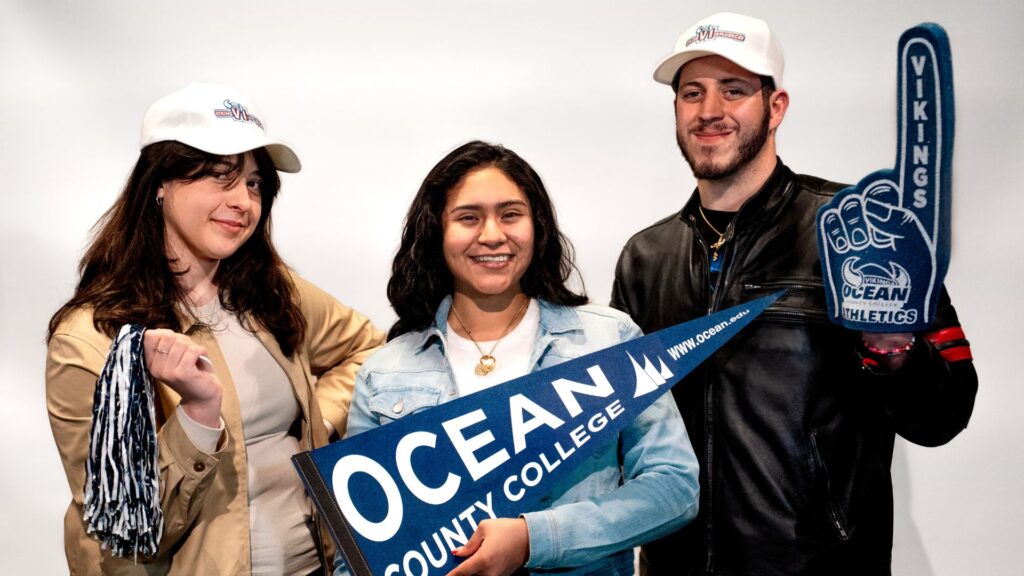Viking Influencers posing with foam hands and ocean flag