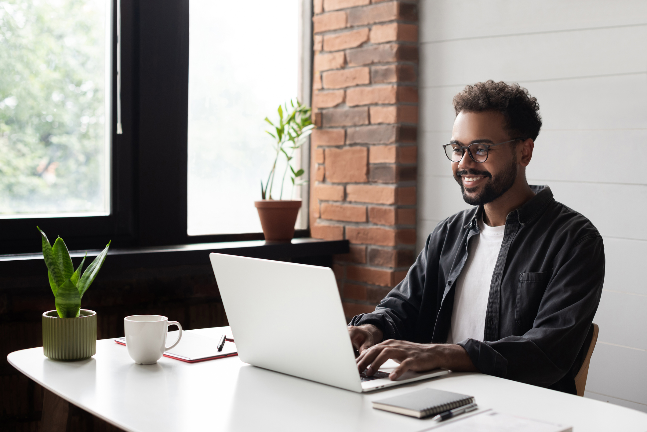 man sitting at desk working on laptop