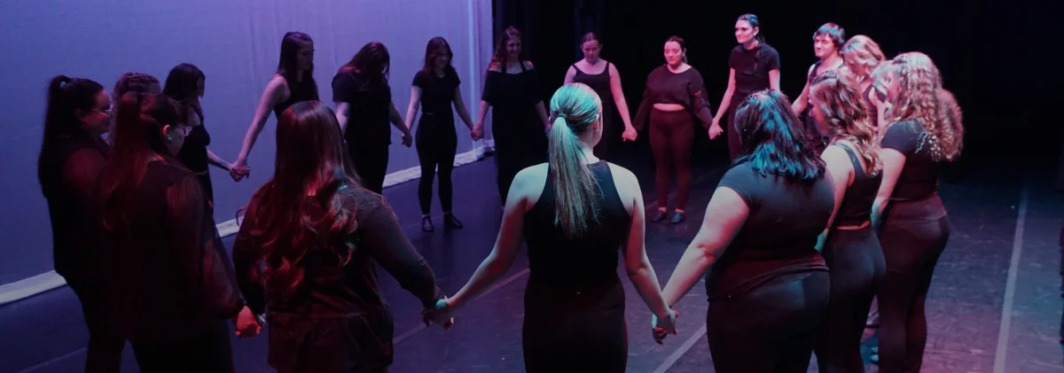 dance club members holding hands in a circle