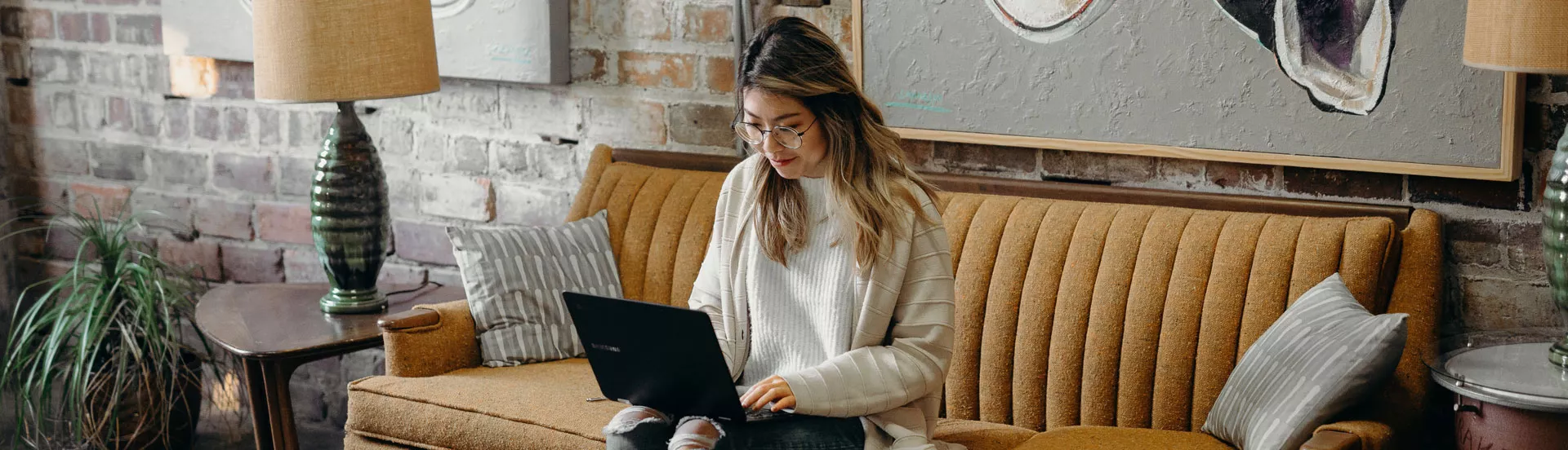 woman on her couch with a computer