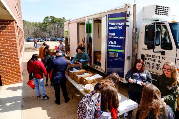 Group of students volunteering outside a big truck, taking donations